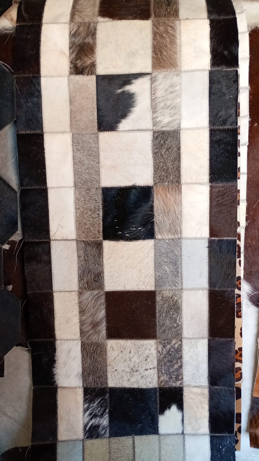 Salón con alfombra artesanal de piel bovina Bamba
